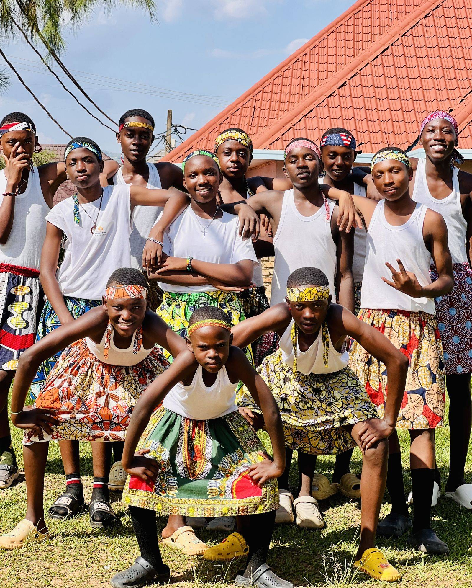 CCF dancers in white vests and African Celtic Kilts, striking playful poses.
