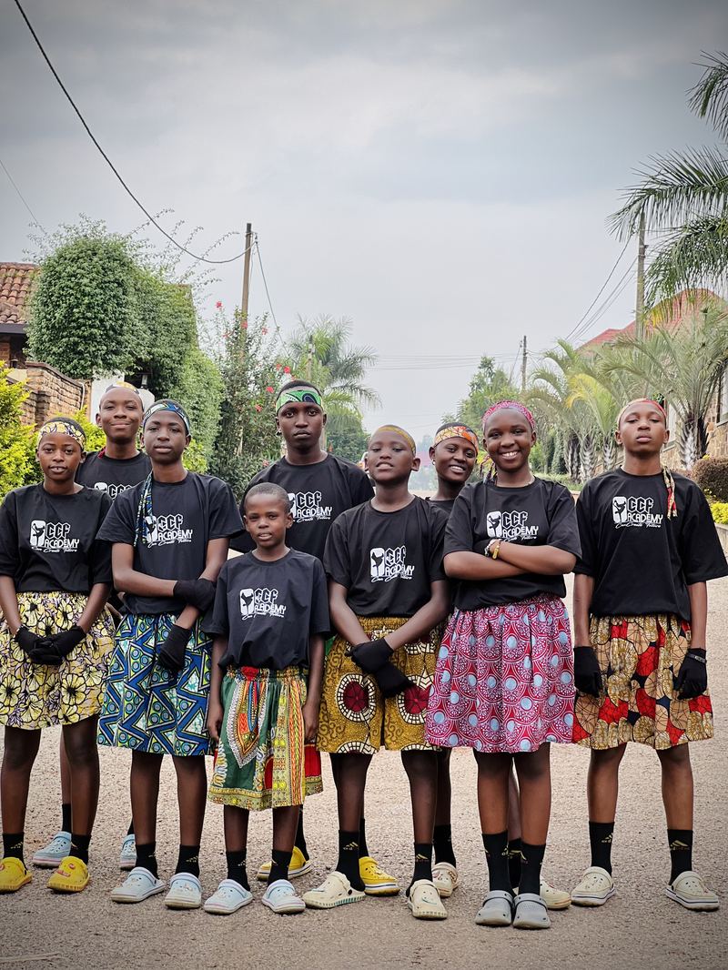 The CCF crew in black academy t-shirts and African-print kilts on a Kigali street.